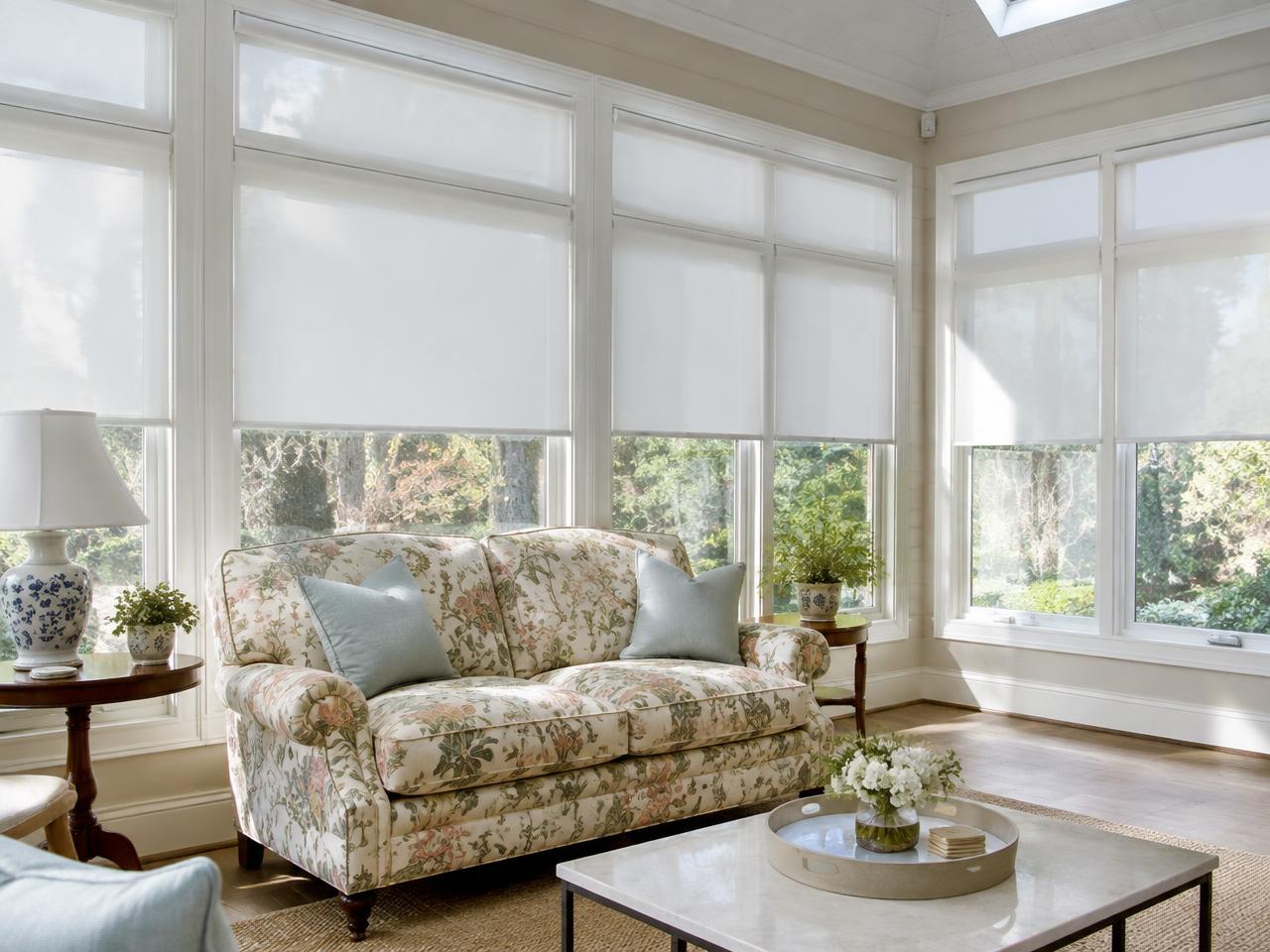 Motorized roller shades and a reupholstered floral loveseat in a Wayland, MA sunroom